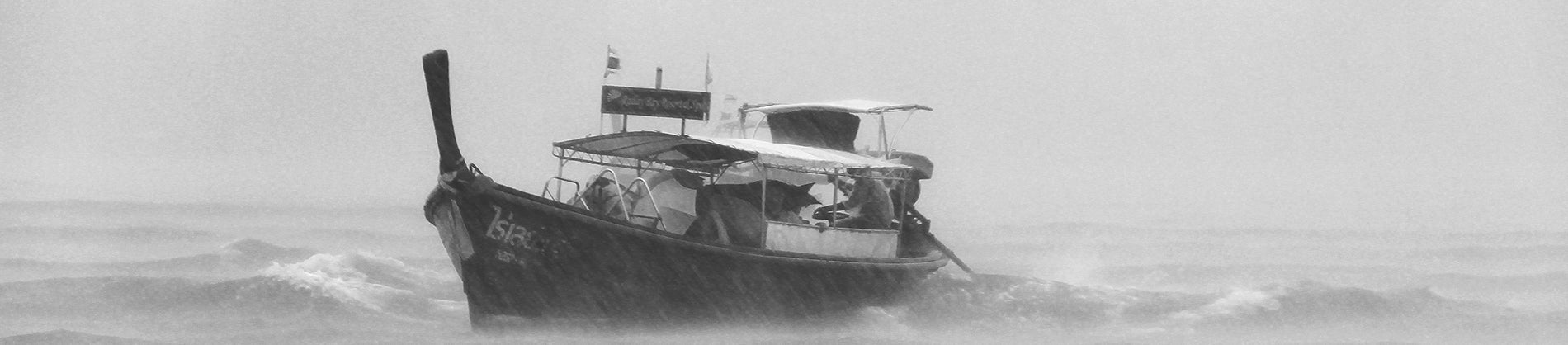 A black and white photo of a boat in the middle of a storm