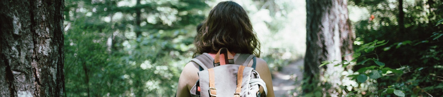 A women with a backpack walking through a forest
